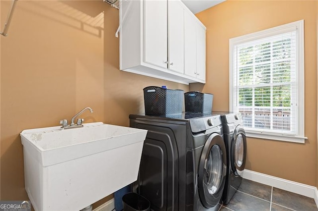 laundry room featuring cabinet space, a sink, separate washer and dryer, dark tile patterned floors, and baseboards