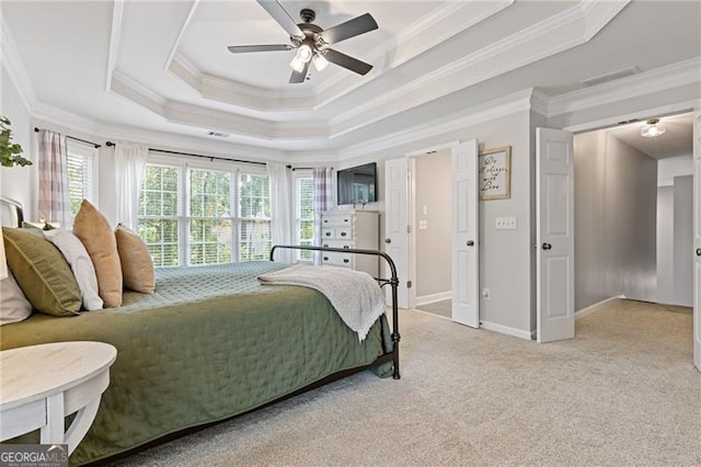 bedroom with light colored carpet, a ceiling fan, baseboards, a tray ceiling, and crown molding