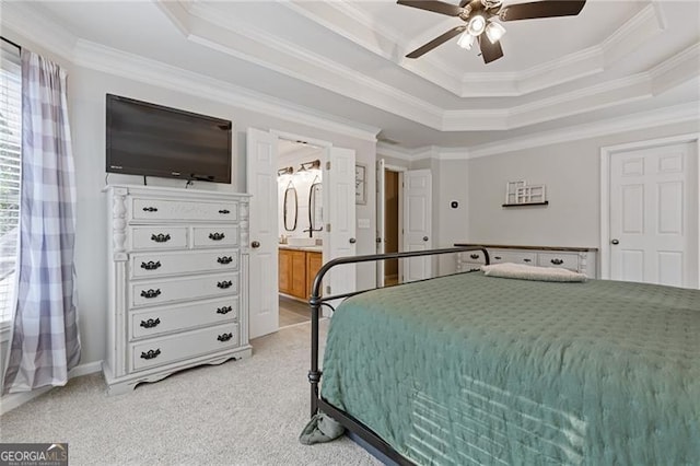 bedroom with ceiling fan, connected bathroom, light colored carpet, a raised ceiling, and crown molding