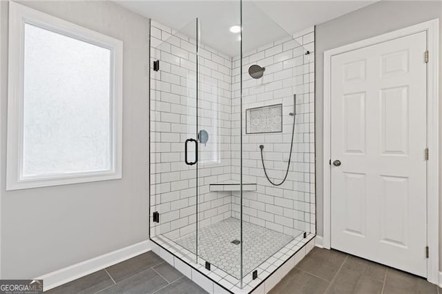 full bathroom with tile patterned flooring, a shower stall, and baseboards