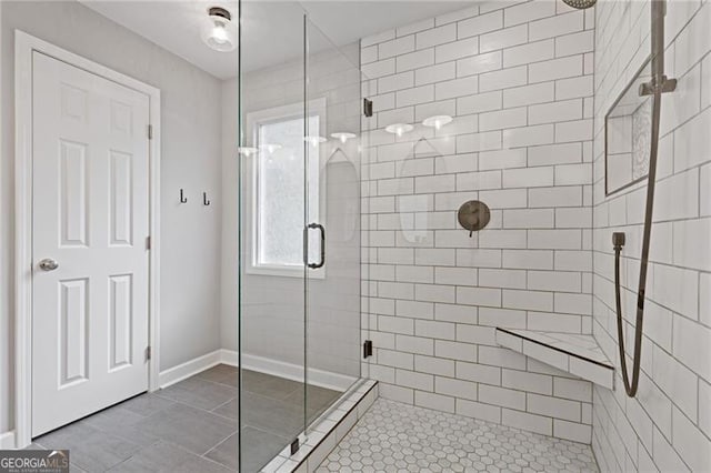 full bath with tile patterned flooring, a shower stall, and baseboards