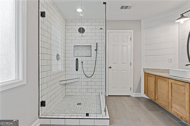 full bathroom featuring a stall shower, baseboards, visible vents, and vanity