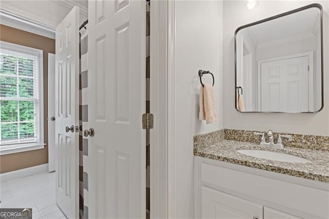 bathroom with baseboards, vanity, ornamental molding, and tile patterned floors