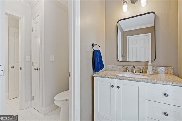 bathroom with toilet, vanity, baseboards, ornamental molding, and tile patterned floors