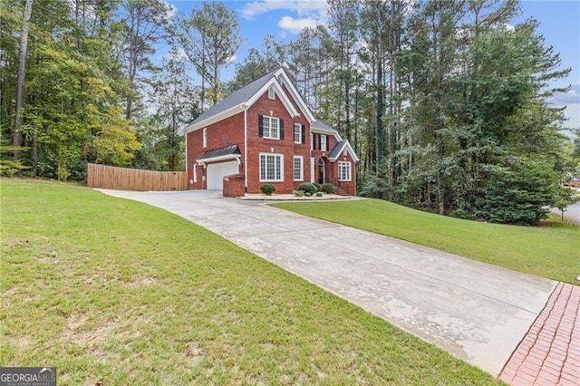 view of front of property featuring an attached garage, fence, a front lawn, and concrete driveway