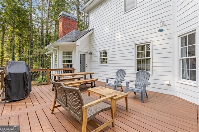 wooden deck featuring outdoor dining area and a grill