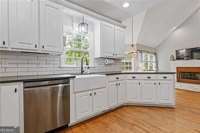 kitchen featuring dark countertops, white cabinets, and dishwasher