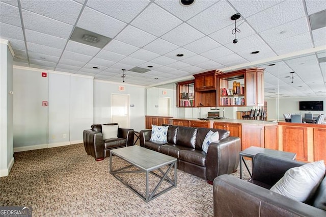 living room featuring light carpet, crown molding, and a drop ceiling