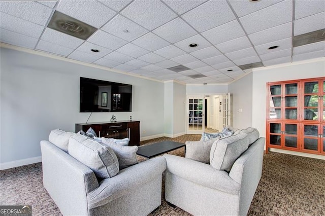 carpeted living room featuring a drop ceiling and ornamental molding