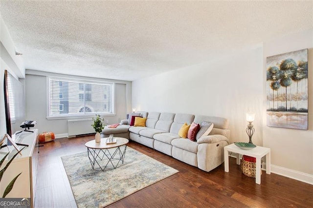 living room featuring a textured ceiling, dark wood-type flooring, and radiator