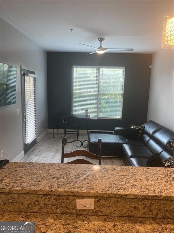 living room featuring ceiling fan and light hardwood / wood-style flooring