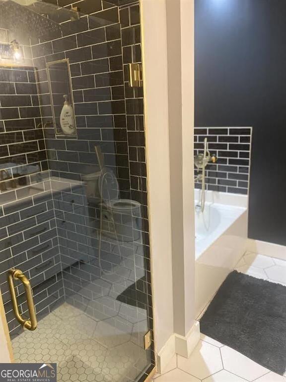 bathroom featuring separate shower and tub and tile patterned flooring