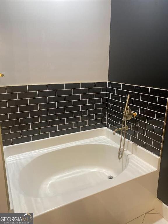 bathroom featuring a tub to relax in and tile patterned flooring