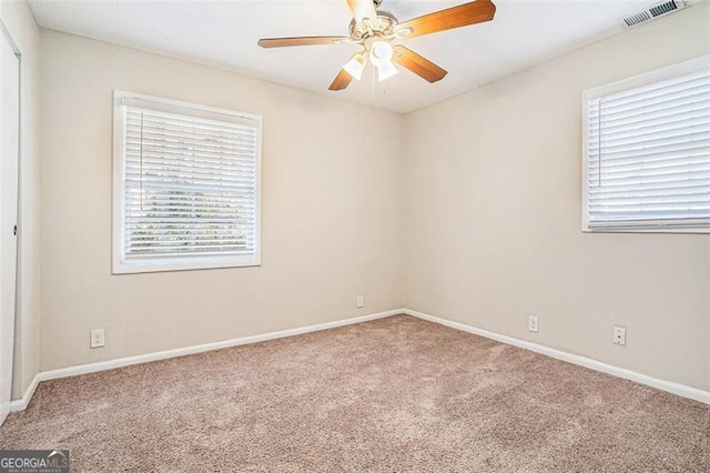 carpeted spare room featuring ceiling fan