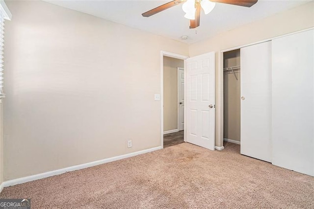 unfurnished bedroom featuring ceiling fan, a closet, and light carpet