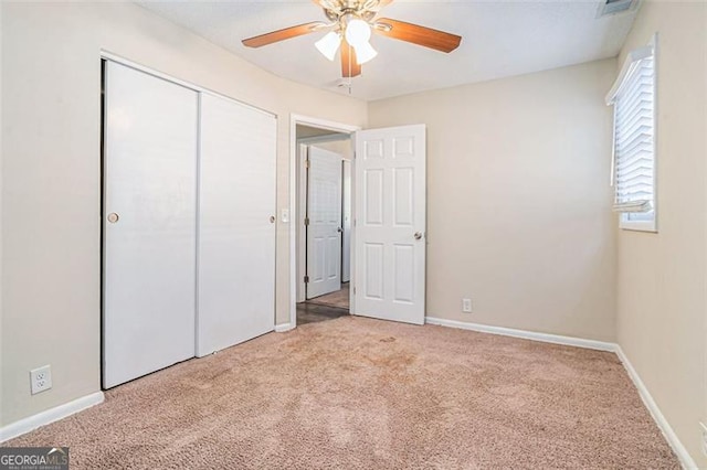 unfurnished bedroom with ceiling fan, a closet, and light colored carpet