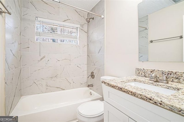 full bathroom featuring vanity, toilet, a textured ceiling, and tiled shower / bath