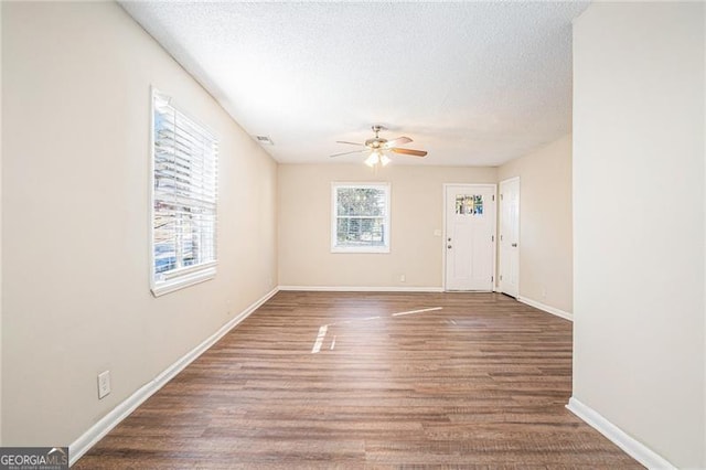 interior space with a textured ceiling, dark hardwood / wood-style floors, and ceiling fan