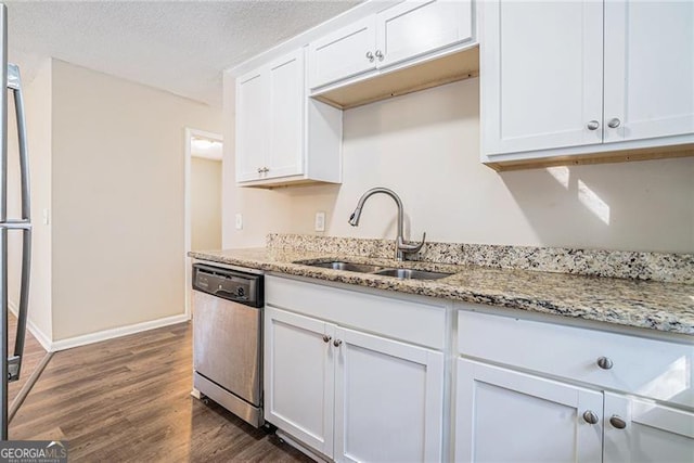 kitchen featuring dishwasher, light stone countertops, white cabinetry, and sink