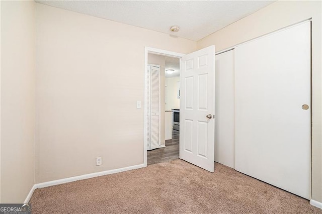 unfurnished bedroom featuring light colored carpet and a closet