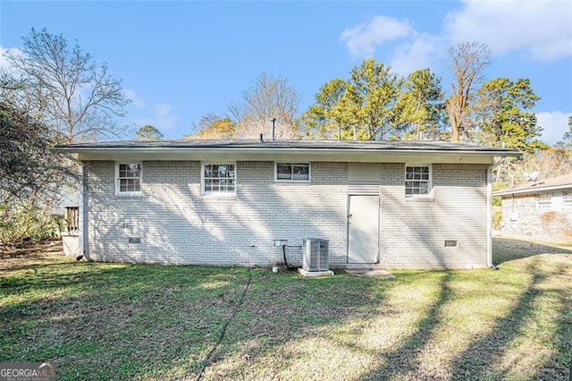 back of house with cooling unit and a yard