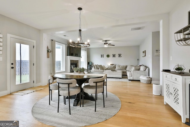 dining area featuring ceiling fan with notable chandelier and light hardwood / wood-style flooring