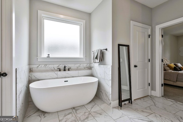 bathroom with a bathing tub and tile walls