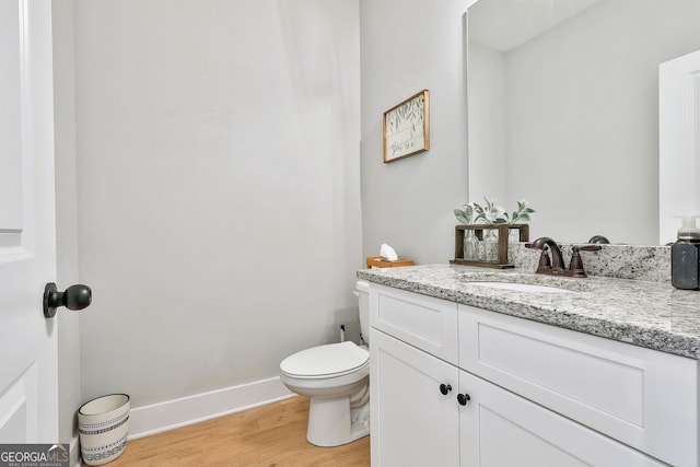 bathroom featuring hardwood / wood-style floors, vanity, and toilet