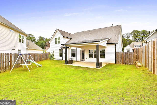 rear view of property featuring a patio area and a lawn