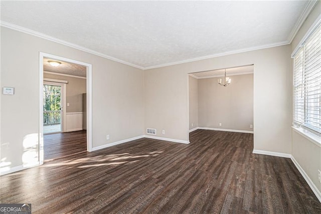 empty room with a wealth of natural light, crown molding, dark hardwood / wood-style flooring, and a notable chandelier