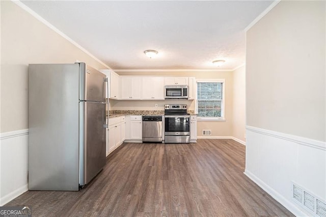 kitchen featuring crown molding, dark hardwood / wood-style flooring, white cabinets, and appliances with stainless steel finishes