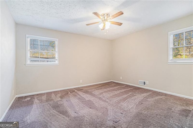 unfurnished room with carpet, a textured ceiling, plenty of natural light, and ceiling fan