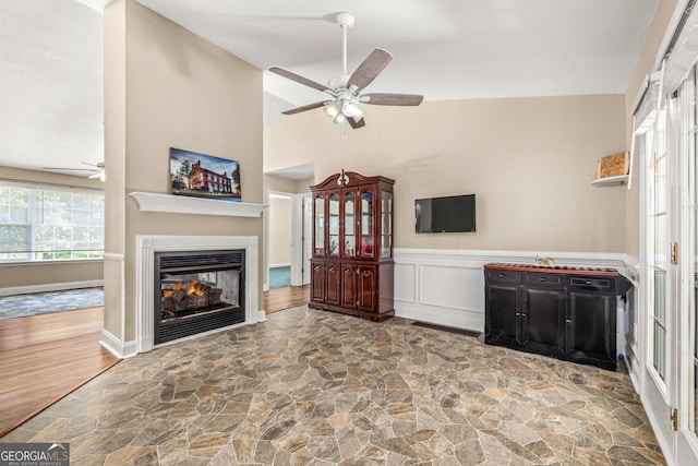 unfurnished living room with ceiling fan and lofted ceiling