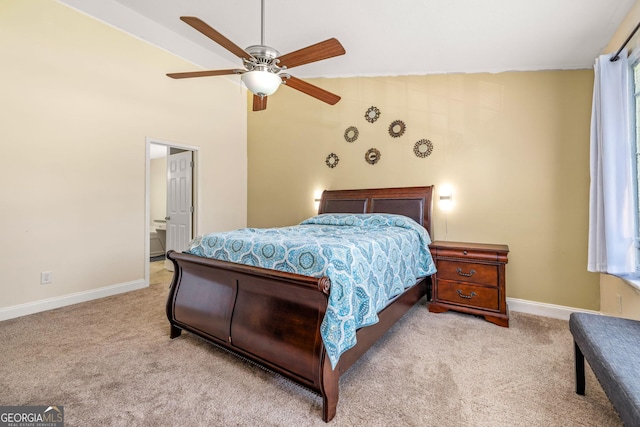 bedroom featuring light colored carpet, ensuite bath, and ceiling fan