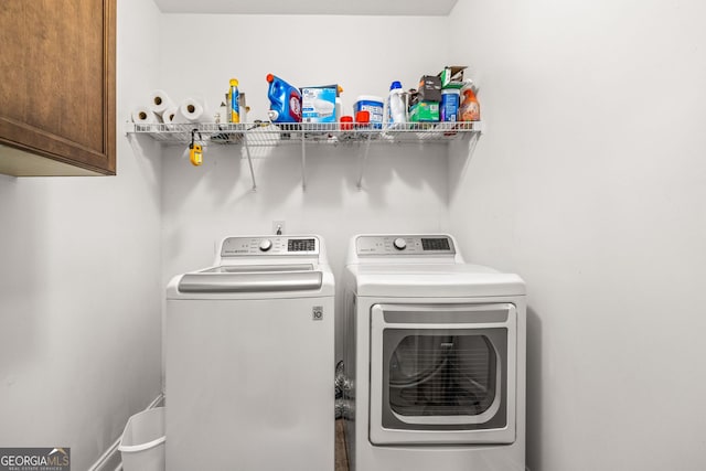 washroom with cabinets and washing machine and clothes dryer