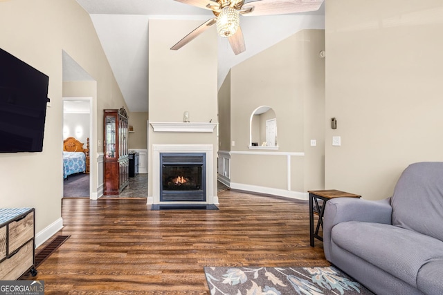 living room featuring dark hardwood / wood-style flooring, ceiling fan, and lofted ceiling