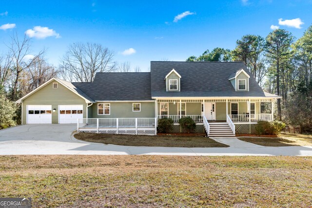 cape cod house featuring a porch, a garage, an outdoor structure, and a front lawn