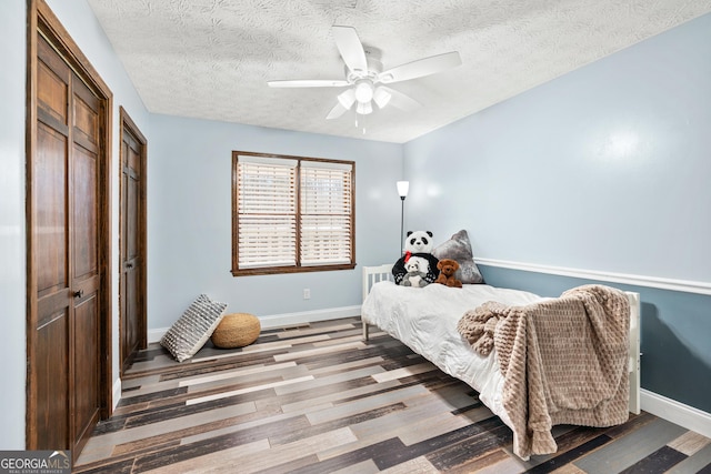 bedroom featuring ceiling fan, a textured ceiling, and hardwood / wood-style flooring