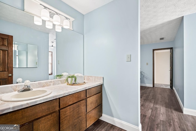 bathroom featuring wood-type flooring, a textured ceiling, and vanity