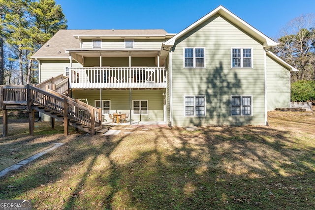 rear view of house featuring a yard and a deck