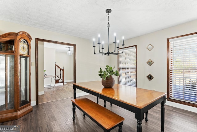 dining area with a textured ceiling, a chandelier, and dark hardwood / wood-style flooring