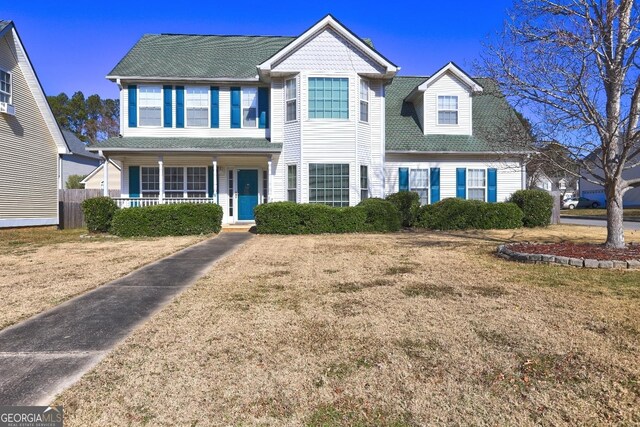 view of front of property with central AC, a front lawn, and covered porch