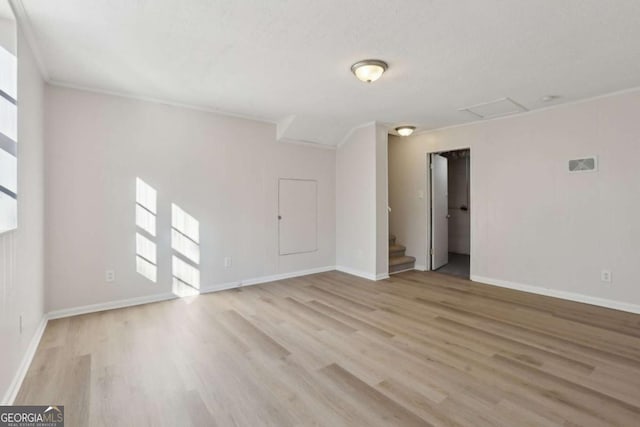 spare room featuring light hardwood / wood-style flooring and a textured ceiling