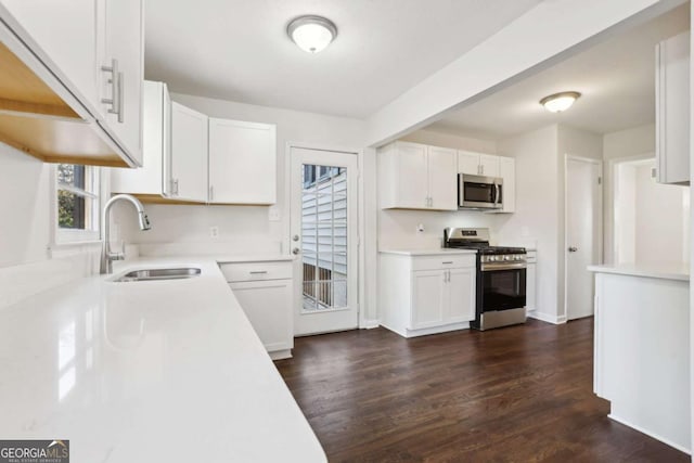 kitchen with dark hardwood / wood-style flooring, stainless steel appliances, white cabinetry, and sink