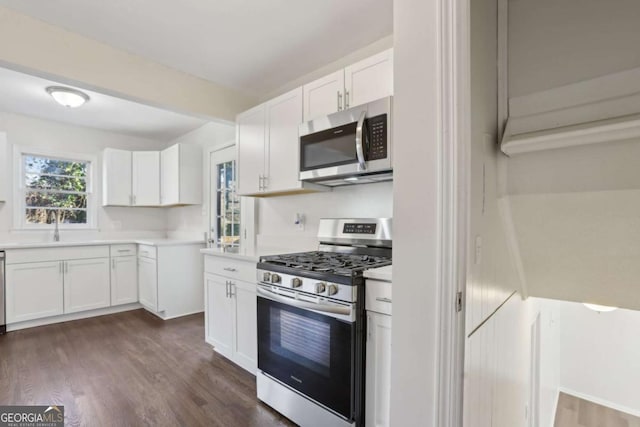 kitchen with white cabinets, dark hardwood / wood-style floors, sink, and appliances with stainless steel finishes