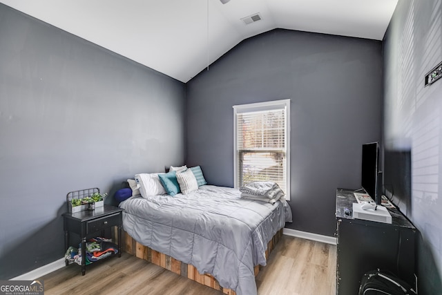 bedroom featuring lofted ceiling and light wood-type flooring