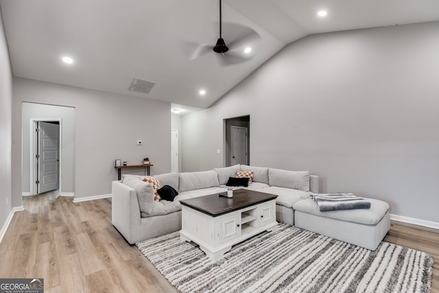 living room featuring ceiling fan, light wood-type flooring, and lofted ceiling