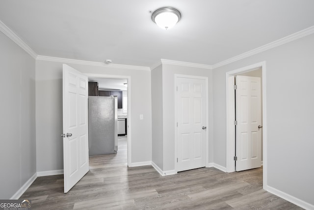 hall with light hardwood / wood-style floors and crown molding