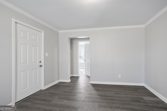 empty room featuring dark hardwood / wood-style flooring and ornamental molding