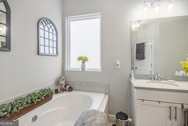 bathroom featuring vanity and a relaxing tiled tub